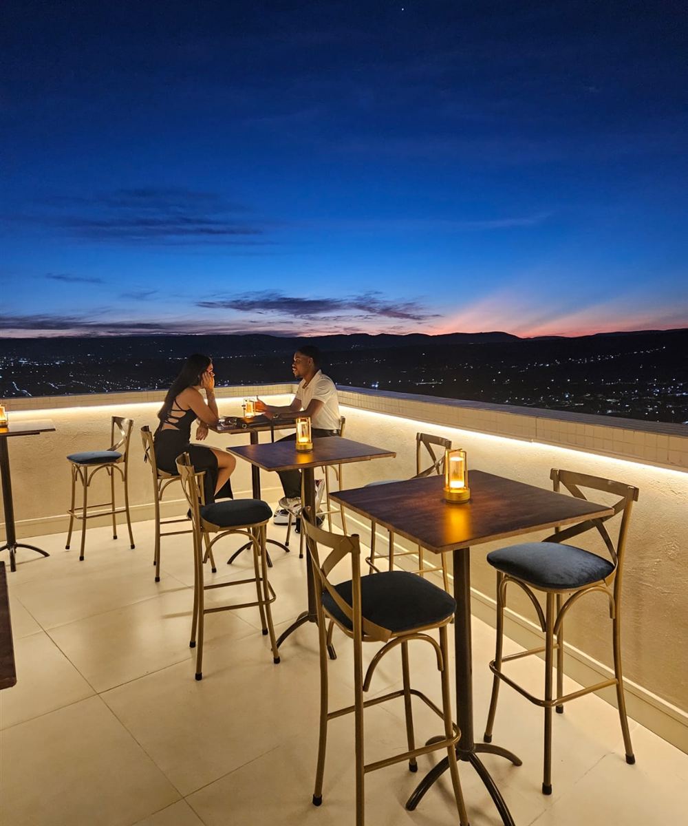 Casal conversando à luz de velas no terraço ao anoitecer