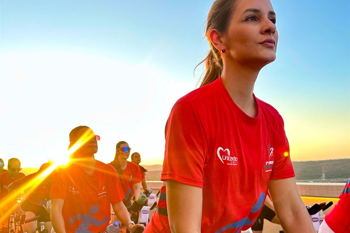 Participantes do Sunset Unicárdio pedalando no terraço ao pôr do sol