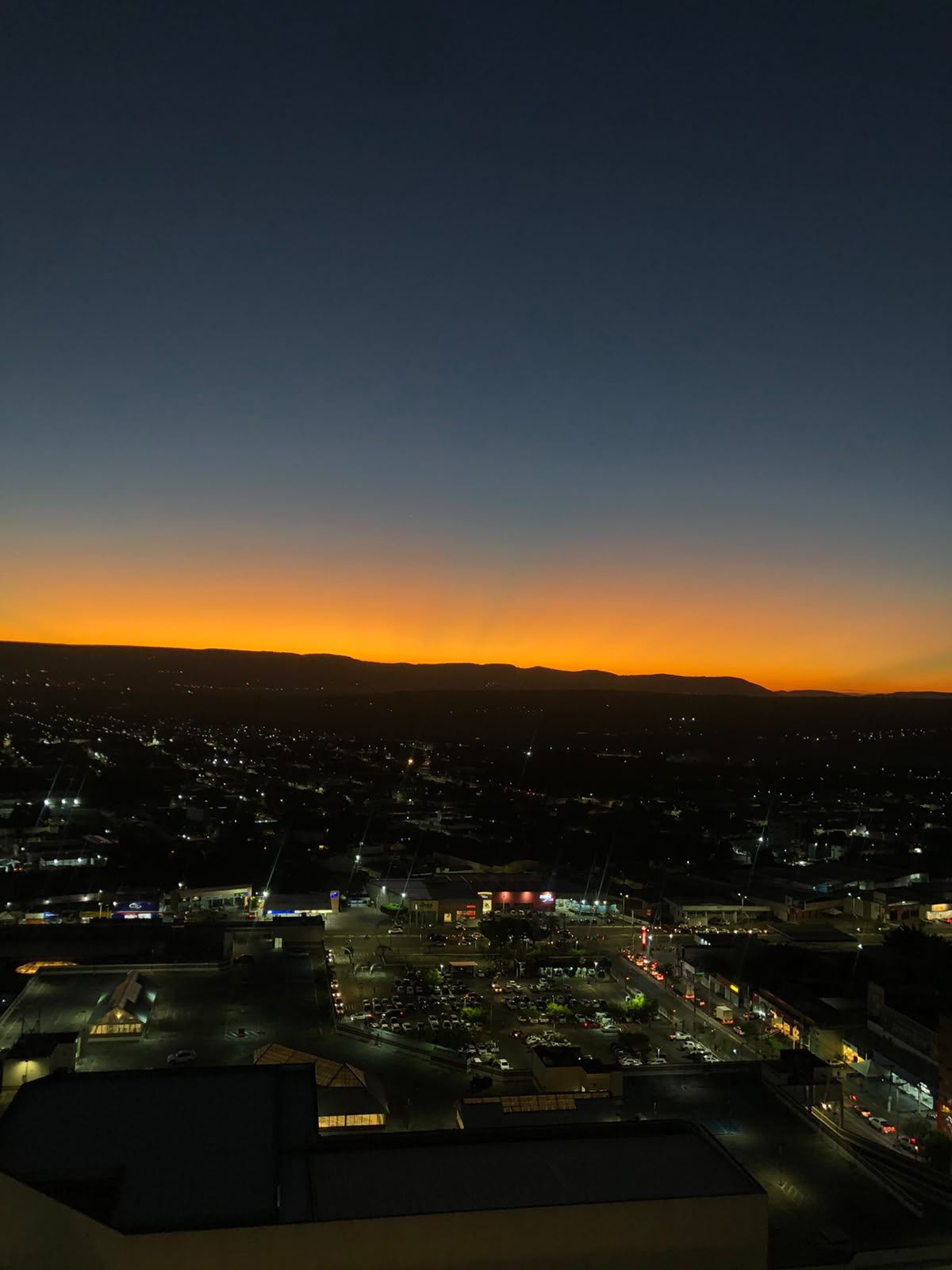 O horizonte da Chapada do Araripe ao pôr do sol, com as luzes da cidade